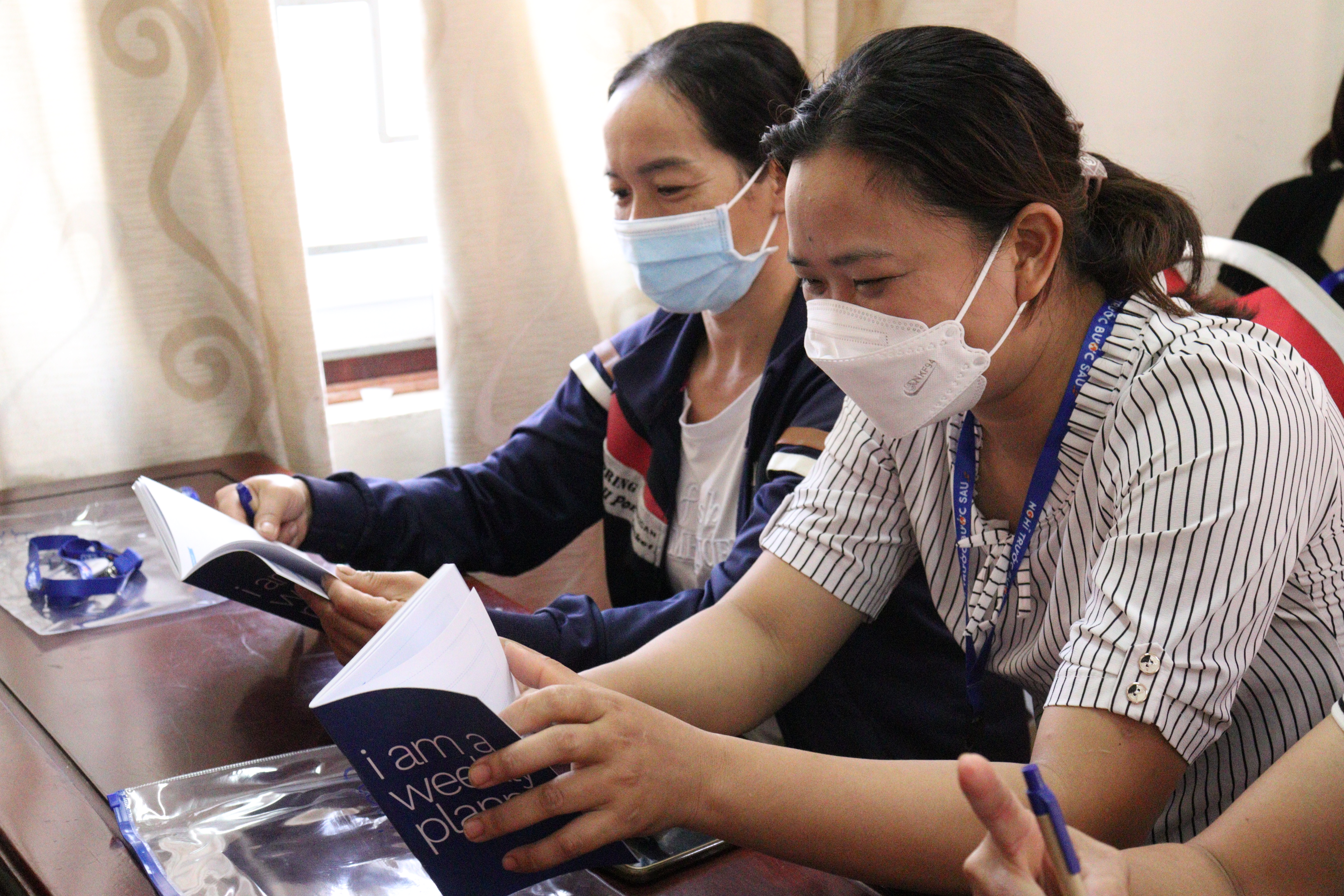 International migrant worker returnees reading information on safe migration during IOM training. Photo: IOM Viet Nam